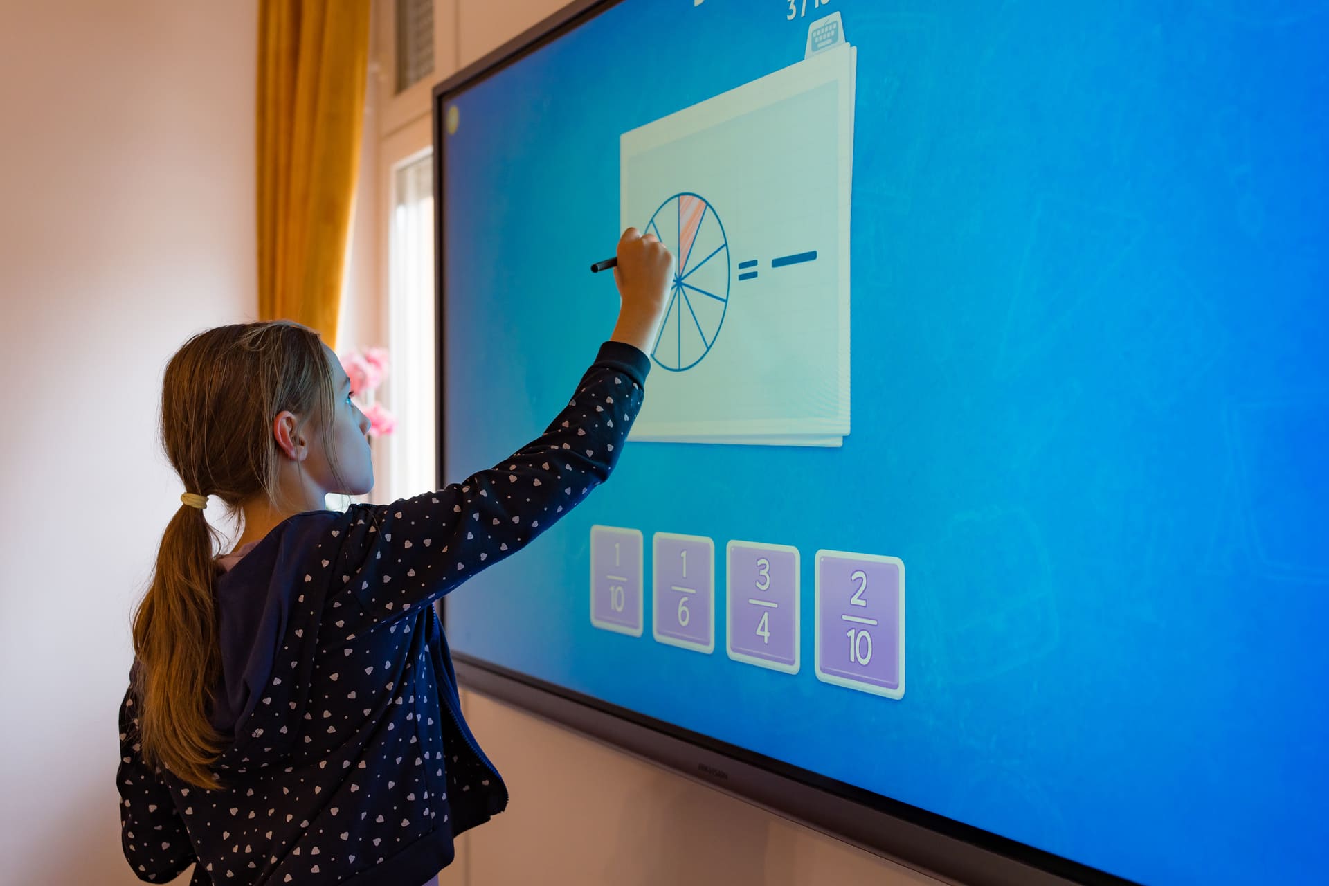 O elevă rezolvă un exercițiu la tabla interactivă Fun Academy